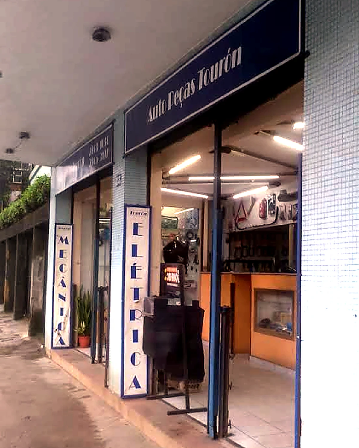 Fachada da Auto Peças Tourón na Rua Coronel Veiga, com as placas de mecânica e elétrica